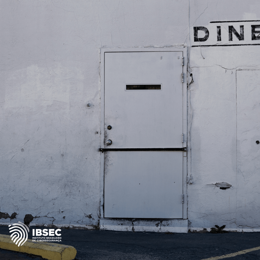 Imagem de uma porta branca, provavelmente nos fundos de alguma fábrica, pois no muro em cima ao aldod ela lemos a palavra "DINER" pintada