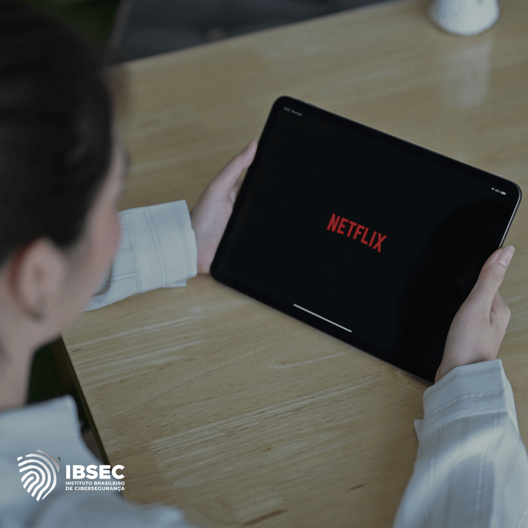 Uma moça branca segurando um tablet com o logo da Netflix na tela