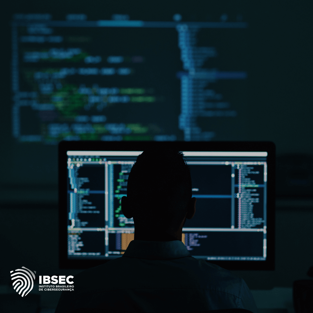 A imagem mostra a silhueta de uma pessoa sentada em frente a um monitor de computador, com várias linhas de código exibidas na tela. No fundo, há mais linhas de código projetadas na parede, criando um ambiente de trabalho focado em programação ou segurança cibernética. No canto inferior esquerdo, está o logotipo do IBSEC (Instituto Brasileiro de Cibersegurança), indicando que a imagem está relacionada a essa instituição.