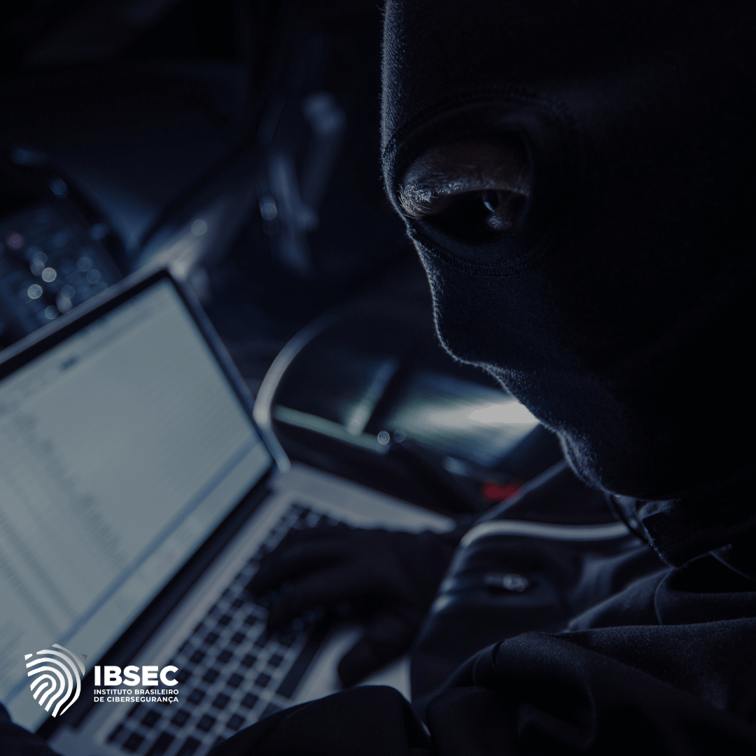 A imagem mostra uma pessoa vestindo uma balaclava preta, operando um laptop em um ambiente escuro, o que sugere uma atividade clandestina ou de hacking. A tela do laptop exibe linhas de texto, típicas de códigos ou comandos, indicando uma possível invasão cibernética. No canto inferior esquerdo, está o logotipo do Instituto Brasileiro de Cibersegurança (IBSEC).