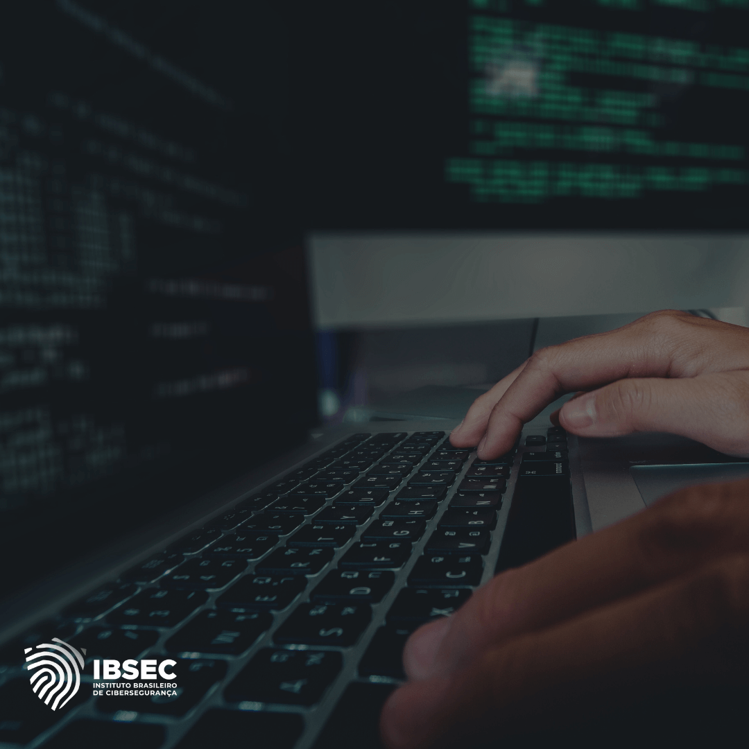 Uma imagem de mãos digitando em um teclado de laptop, com uma tela de computador ao fundo exibindo código. O logo do IBSEC, Instituto Brasileiro de Cibersegurança, está localizado no canto inferior esquerdo.