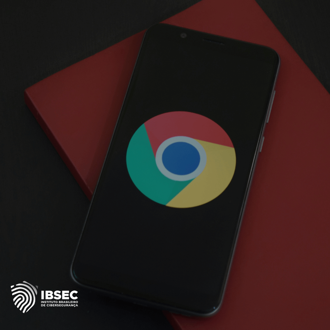 Imagem de um smartphone com o logotipo do navegador Google Chrome exibido na tela. O aparelho está apoiado sobre um objeto vermelho, com o logo do Instituto Brasileiro de Cibersegurança (IBSEC) visível no canto inferior esquerdo. A imagem remete a temas relacionados à segurança na navegação online ou à proteção de dispositivos móveis.